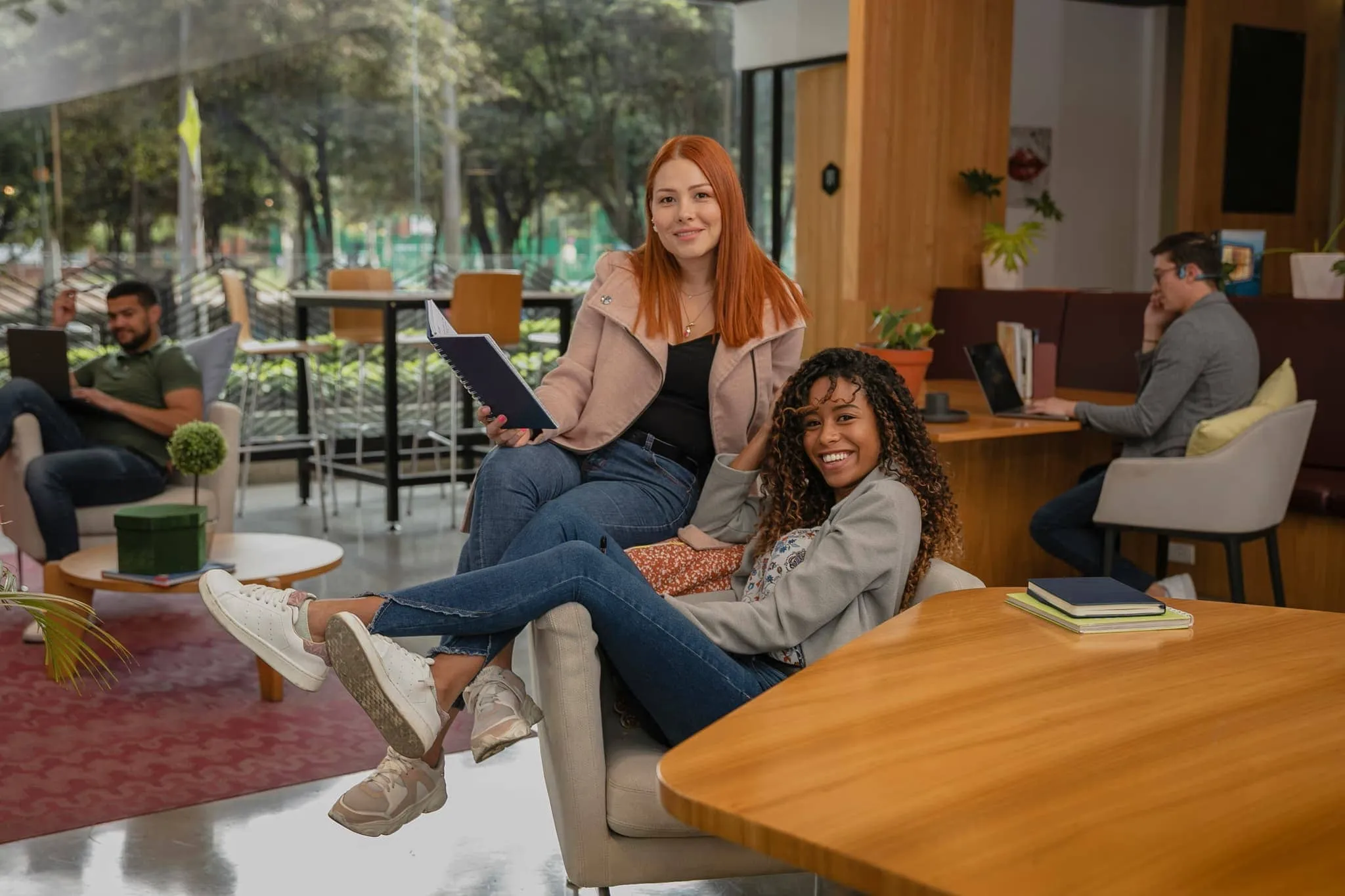 Two colleagues sharing a notebook in a bright office