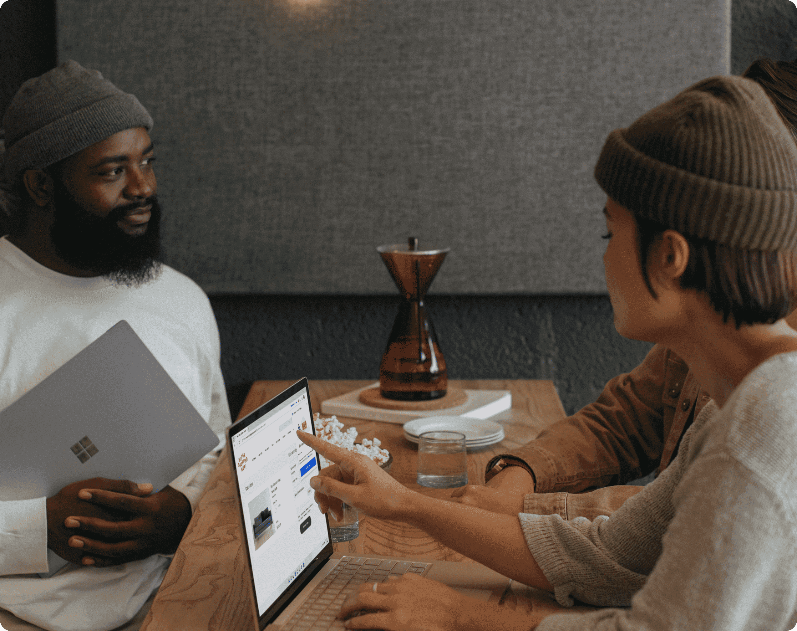Clear and transparent pricing Small group collaborating at a table with laptops while reviewing information on a screen